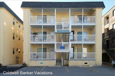 an apartment building with multiple balconies and balconyes on the second floor, next to parking lot