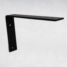 a black shelf mounted to the side of a wall