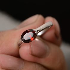 This is a gorgeous handmade creation. Its beauty is its simplicity & Elegance. The 6*8mm oval shape natural garnet (January birthstone) is crafted in solid sterling silver and with rhodium plated. All item is sent in a beautiful gift box You can realize more lovely stuff clicking the link https://www.etsy.com/shop/knightjewelry?refshopsection_shophome_leftnav Please leave the correct address and you phone number for delivering successfully. Blacksmithing Ideas, January Birthstone Rings, Sterling Silver Garnet Ring, Garnet Engagement Ring, Red Garnet Ring, Ruby Rings, Unique Jewelry Gifts, Dungeons Dragons, Sterling Silver Engagement Rings