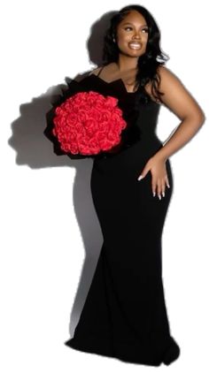 a woman in a long black dress holding a bouquet of red roses on her shoulder