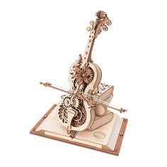 a wooden model of a violin on top of a piece of paper with an intricate design