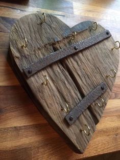 a heart shaped wooden box with two straps on it's sides and rivets in the middle