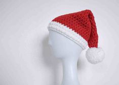 a white mannequin head wearing a red and white knitted santa hat