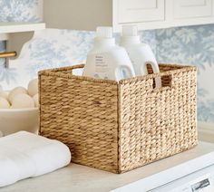 a basket that has some bottles in it on top of a counter next to a dishwasher