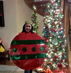 a woman holding up a giant red and green christmas decoration