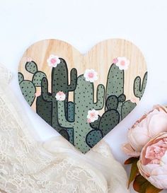 a heart shaped wooden decoration with flowers and cacti