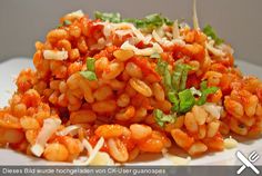 a white plate topped with pasta covered in sauce and garnished with parsley