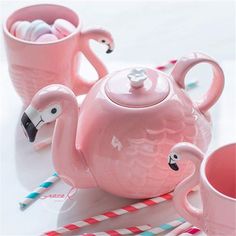 pink tea set with flamingos and candy canes on white table top next to cup