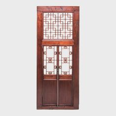 A hallmark of Qing-dynasty domestic architecture, hand-carved lattice doors such as this one were used in provincial courtyard homes to allow light and air into a room while maintaining privacy. Graced with vertical brass pulls, two latticed doors are set within a frame, topped with a transom of geometric fretwork. Stately and stunning, this functional door is a statement wall-mounted sculpture, entrance way, or room divider. Steel Lattice Door, Chinese Wall Decor, Chinese Lattice, Courtyard Homes, Asian Wall Decor, Chinese Door, Antique Chinese Furniture, Chinese Wall, Entrance Way