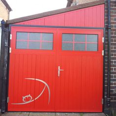 a red garage door painted with the word love on it and an image of a cat