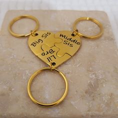 a gold keychain that has two pieces of puzzle in the shape of a heart