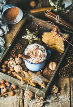 a wooden tray topped with cookies and other holiday treats on top of a wood table