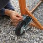 a person is working on an object in the gravel near a wooden table and mirror