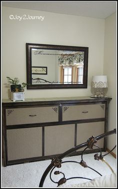 a dresser with a mirror on top of it in a room that has carpeted flooring