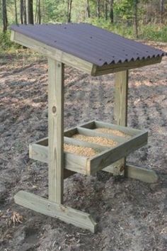 a wooden bench sitting in the middle of a forest filled with lots of dirt and grass