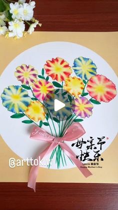 a bouquet of flowers on top of a white plate with a pink ribbon around it