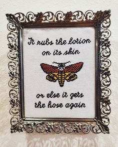 a cross stitch picture frame with an insect on it