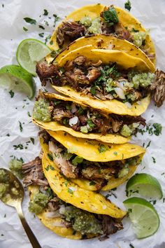 three tacos with meat, broccoli, and mushrooms on white parchment paper