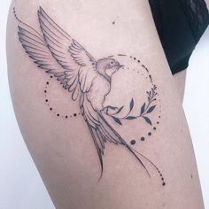 a woman's thigh with a bird tattoo on it