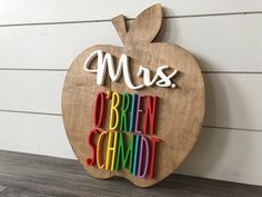 an apple shaped sign with the word mus written in multicolored letters