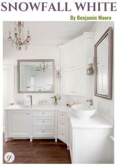 a white bathroom with two sinks and a large mirror on the wall over it's vanity