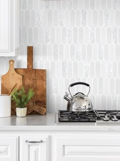 a tea kettle sitting on top of a stove next to a cutting board