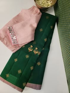 Green Kanchipuram organza (kora ) silk saree with traditional kolam buttis and a contrast Dusty pink selvedge featuring Kanchipuram silk pallu with thin zari lines in Dusty pink. The uniqueness of this saree, is that the body is organza whereas the pallu portion is silk and they are woven in one loom. The pallu features geometric, Rudhraksham and Mayil patterns in pure gold zari. Blouse: Dusty pink Kanchipuram silk Unique Saree Colour Combinations, Contrast Blouses For Silk Sarees, Geometrical Saree Design, Green And Pink Combination Pattu Sarees, Unique Blouse Designs Saree, Pink Silk Blouse Piece With Pallu, Contrast Blouse Designs, Pink Saree Contrast Blouse, Green Saree Contrast Blouse