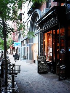 an empty sidewalk in front of a building with a sign on the door that says frank's