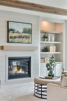 a living room filled with furniture and a fire place under a painting on the wall