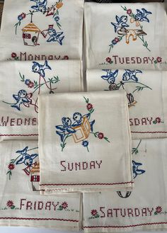 six embroidered tea towels sitting on top of a table