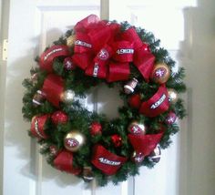 a wreath is hanging on the front door decorated with candy bars and christmas ornaments,