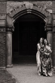 two women standing in front of an archway