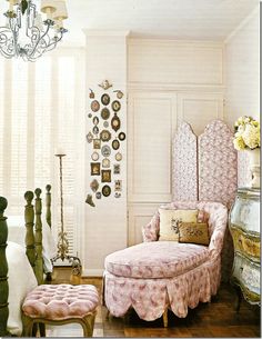 a bedroom with white walls and pink furniture