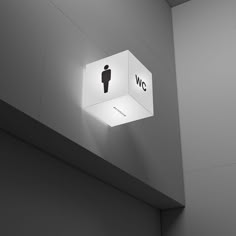 a white light hanging from the side of a wall next to a toilet paper dispenser