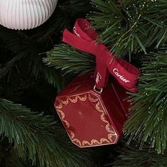 a red ornament hanging from a christmas tree