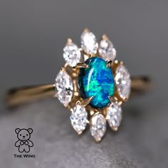 a blue opal surrounded by white diamonds on a gold ring