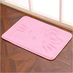 a pink mat that says hello kitty on it's side, sitting on the floor