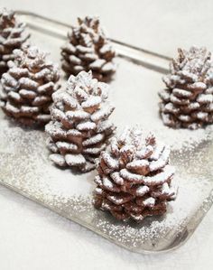 small pine cones covered in powdered sugar on a tray