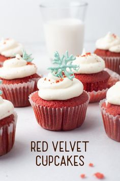 red velvet cupcakes with frosting and sprinkles next to a glass of milk