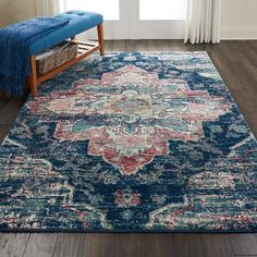 a blue area rug with an ornate design on the top and bottom, in front of a window