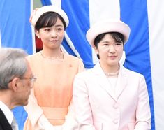 two women standing next to each other wearing hats