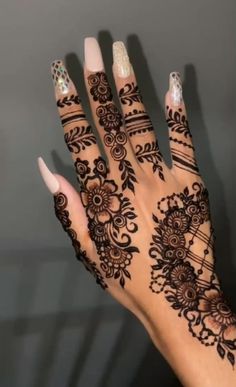 a woman's hand with henna tattoos on it