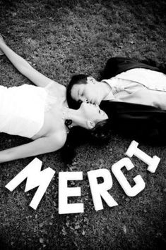 a man and woman laying on the ground next to each other with words that spell out merci