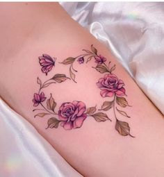 a woman's thigh with pink roses on it and leaves around the thighs,