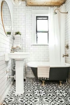 the bathroom is decorated in white and black with an old - fashioned claw foot tub