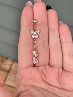 a woman's hand holding a gold ring with three flowers on the front and side