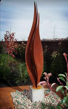 a large metal sculpture sitting in the middle of a garden