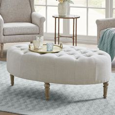 a living room scene with focus on the coffee table and ottoman, along with two chairs