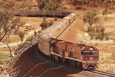 a train is traveling down the tracks in the desert