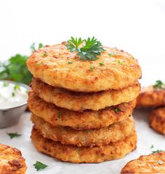 a stack of food sitting on top of a white plate next to some dipping sauce